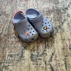 Purple crocks with a pink strap and jibbits